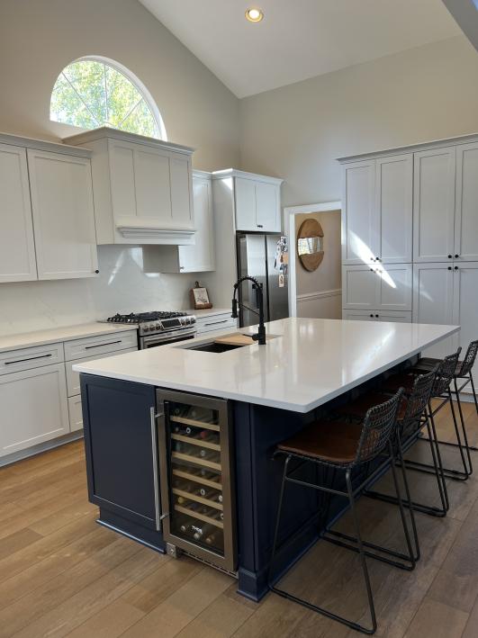 A modern kitchen featuring a spacious island with a sink, surrounded by cabinets and appliances.