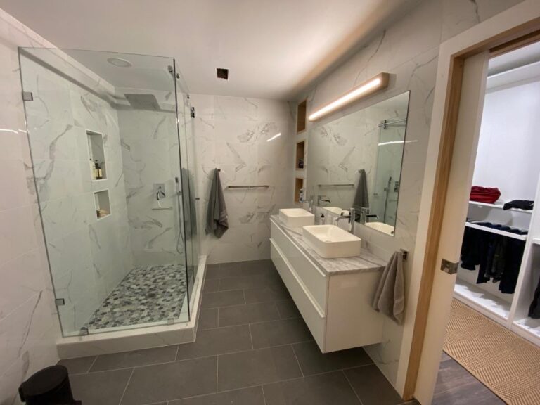 A modern bathroom featuring a walk-in shower and a sleek sink, showcasing contemporary design elements.
