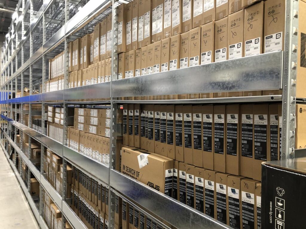 A spacious warehouse interior featuring tall shelves filled with numerous stacked boxes.