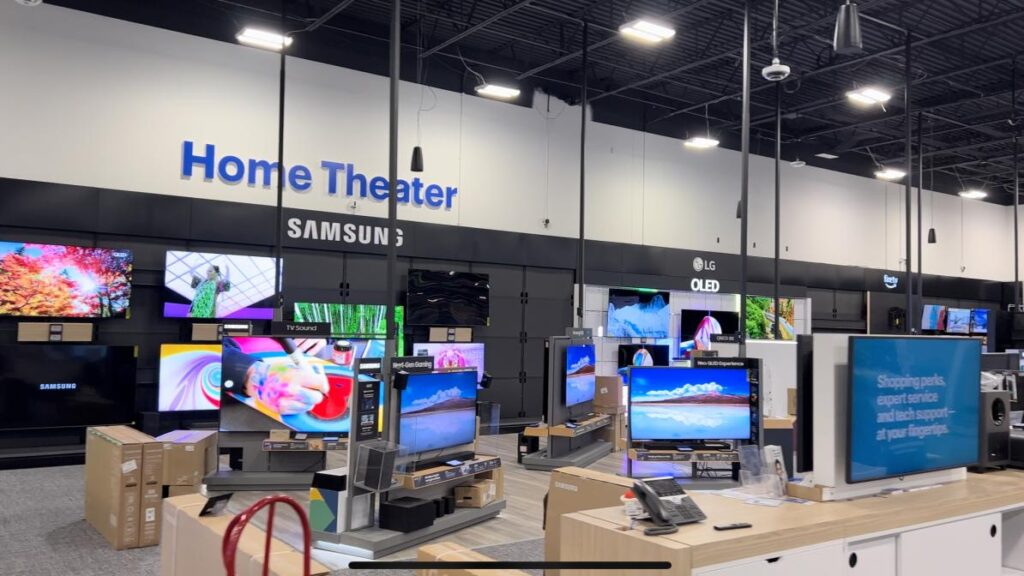 A retail store showcasing various televisions and electronics arranged for customer viewing.